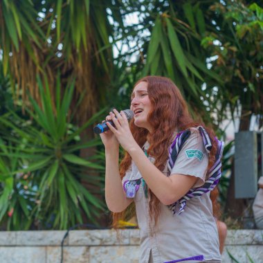 Hayfa, İsrail - Haziran 06, 2024: Inbar Golan, rehine ailelerine destek veren kalabalığa şarkı söylüyor ve İsrail 'in Hayfa kentinde bir rehine anlaşması çağrısında bulunuyor