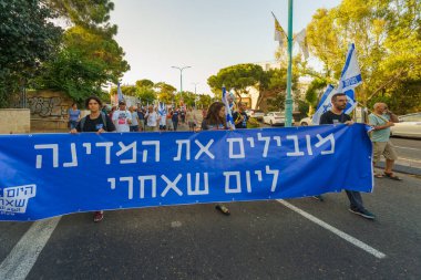 Hayfa, İsrail - Haziran 08, 2024: İnsanlar hükümete karşı çeşitli işaret ve bayraklarla yeni seçimler çağrısında bulunan bir protesto yürüyüşüne (öğrenci grubu) katılıyor. Hayfa, İsrail