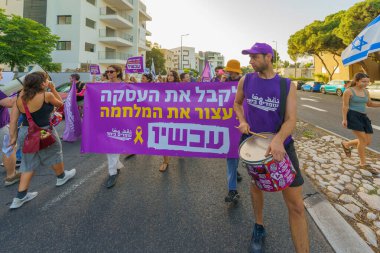 Hayfa, İsrail - Haziran 08, 2024: İnsanlar hükümete karşı çeşitli tabela ve bayraklarla birlikte yeni seçimler çağrısında bulunarak bir protesto yürüyüşüne katılıyor. Hayfa, İsrail
