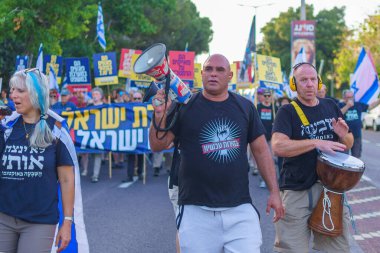 Hayfa, İsrail - Haziran 08, 2024: İnsanlar hükümete karşı çeşitli tabelalar ve bayraklarla yeni seçimler çağrısında bulunarak bir protesto yürüyüşüne katılıyor. Hayfa, İsrail