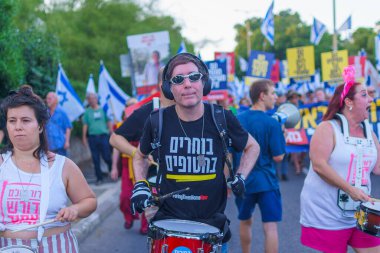 Hayfa, İsrail - Haziran 08, 2024: İnsanlar hükümete karşı çeşitli tabelalar ve bayraklarla yeni seçimler çağrısında bulunarak bir protesto yürüyüşüne katılıyor. Hayfa, İsrail