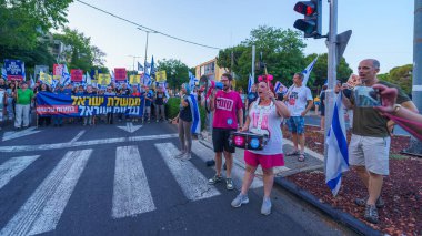 Hayfa, İsrail - Haziran 08, 2024: İnsanlar hükümete karşı çeşitli tabelalar ve bayraklarla yeni seçimler çağrısında bulunarak bir protesto yürüyüşüne katılıyor. Hayfa, İsrail