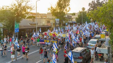 Hayfa, İsrail - Haziran 08, 2024: İnsanlar hükümete karşı çeşitli tabelalar ve bayraklarla yeni seçimler çağrısında bulunarak bir protesto yürüyüşüne katılıyor. Hayfa, İsrail