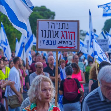 Hayfa, İsrail - 08 Haziran 2024: Hükümete karşı düzenlenen bir meclis protestosunda çeşitli tabela ve bayraklara sahip bir kalabalık yeni seçim çağrısında bulundu. Hayfa, İsrail