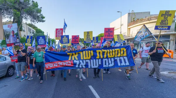 stock image Haifa, Israel - June 08, 2024: People take part in a protest march, with various signs and flags, against the government, calling for new elections. Haifa, Israel