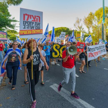 Hayfa, İsrail - 15 Haziran 2024: İnsanlar hükümete karşı çeşitli tabela ve bayraklarla bir protesto yürüyüşüne katılarak yeni seçimler çağrısında bulundu. Hayfa, İsrail