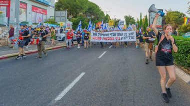 Hayfa, İsrail - 15 Haziran 2024: İnsanlar hükümete karşı çeşitli tabela ve bayraklarla bir protesto yürüyüşüne katılarak yeni seçimler çağrısında bulundu. Hayfa, İsrail