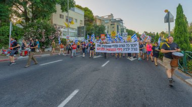 Hayfa, İsrail - 15 Haziran 2024: İnsanlar hükümete karşı çeşitli tabela ve bayraklarla bir protesto yürüyüşüne katılarak yeni seçimler çağrısında bulundu. Hayfa, İsrail