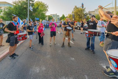 Hayfa, İsrail - 15 Haziran 2024: İnsanlar hükümete karşı çeşitli tabela ve bayraklarla bir protesto yürüyüşüne katılarak yeni seçimler çağrısında bulundu. Hayfa, İsrail