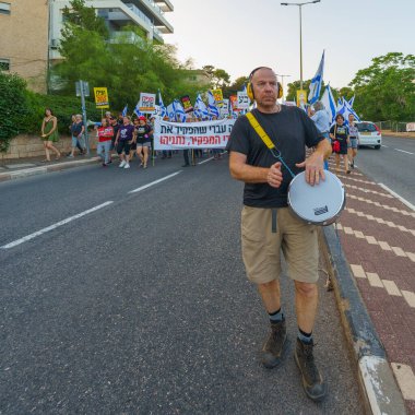 Hayfa, İsrail - 15 Haziran 2024: İnsanlar hükümete karşı çeşitli tabela ve bayraklarla bir protesto yürüyüşüne katılarak yeni seçimler çağrısında bulundu. Hayfa, İsrail