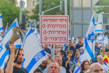 Hayfa, İsrail - 15 Haziran 2024: Çeşitli tabelaları ve bayrakları olan kalabalık hükümeti protesto ederek yeni seçim çağrısında bulundu. Hayfa, İsrail