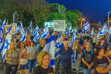Hayfa, İsrail - 15 Haziran 2024: Çeşitli tabelaları ve bayrakları olan kalabalık hükümeti protesto ederek yeni seçim çağrısında bulundu. Hayfa, İsrail