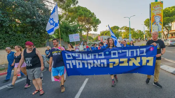 stock image Haifa, Israel - June 08, 2024: People take part in a protest march (academy group), with various signs and flags, against the government, calling for new elections. Haifa, Israel