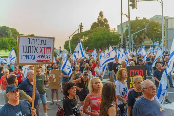 stock image Haifa, Israel - June 15, 2024: Crowd of people with various signs and flags protest against the government, calling for new elections. Haifa, Israel