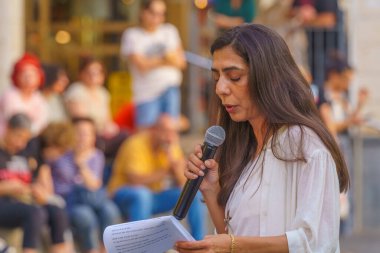 Hayfa, İsrail - 20 Haziran 2024: Hayfa-Boston Bağlantı Bürosu müdürü Hila Pniel-Perlman, İsrail 'in Hayfa kentindeki rehine ailelerine yönelik bir destek toplantısında kalabalığa seslendi.