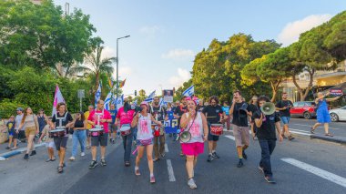 Hayfa, İsrail - 22 Haziran 2024: İnsanlar hükümete karşı çeşitli tabela ve bayraklarla bir protesto yürüyüşüne katılarak yeni seçimler çağrısında bulundu. Hayfa, İsrail