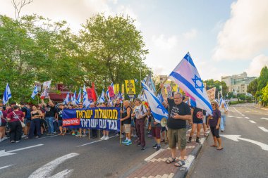 Hayfa, İsrail - 22 Haziran 2024: İnsanlar hükümete karşı çeşitli tabela ve bayraklarla bir protesto yürüyüşüne katılarak yeni seçimler çağrısında bulundu. Hayfa, İsrail