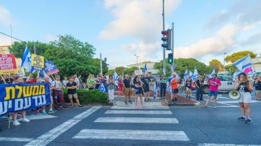 Hayfa, İsrail - 22 Haziran 2024: İnsanlar hükümete karşı çeşitli tabela ve bayraklarla bir protesto yürüyüşüne katılarak yeni seçimler çağrısında bulundu. Hayfa, İsrail