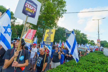 Hayfa, İsrail - 22 Haziran 2024: İnsanlar hükümete karşı çeşitli tabela ve bayraklarla bir protesto yürüyüşüne katılarak yeni seçimler çağrısında bulundu. Hayfa, İsrail