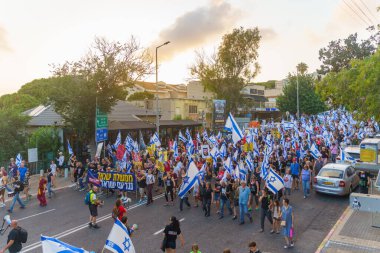 Hayfa, İsrail - 22 Haziran 2024: İnsanlar hükümete karşı çeşitli tabela ve bayraklarla bir protesto yürüyüşüne katılarak yeni seçimler çağrısında bulundu. Hayfa, İsrail