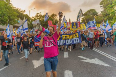 Hayfa, İsrail - 22 Haziran 2024: İnsanlar hükümete karşı çeşitli tabela ve bayraklarla bir protesto yürüyüşüne katılarak yeni seçimler çağrısında bulundu. Hayfa, İsrail