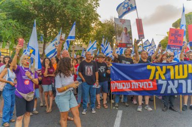 Hayfa, İsrail - 22 Haziran 2024: İnsanlar hükümete karşı çeşitli tabela ve bayraklarla bir protesto yürüyüşüne katılarak yeni seçimler çağrısında bulundu. Hayfa, İsrail