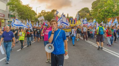 Hayfa, İsrail - 22 Haziran 2024: İnsanlar hükümete karşı çeşitli tabela ve bayraklarla bir protesto yürüyüşüne katılarak yeni seçimler çağrısında bulundu. Hayfa, İsrail