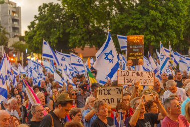 Hayfa, İsrail - 22 Haziran 2024: Çeşitli tabelaları ve bayrakları olan kalabalık hükümeti protesto ederek yeni seçim çağrısında bulundu. Hayfa, İsrail