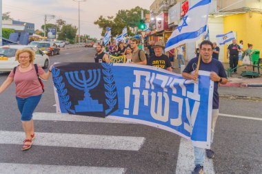 Hayfa, İsrail - 27 Haziran 2024: Çeşitli tabela ve bayraklara sahip insanlar hükümeti protesto ederek yeni seçim çağrısında bulundular. Hayfa, İsrail