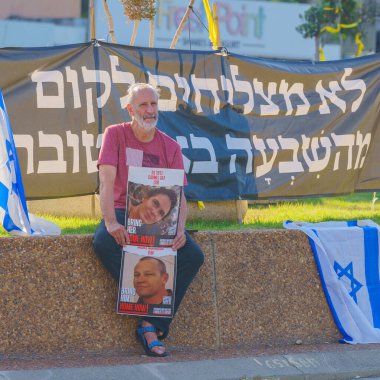 Hayfa, İsrail - 26 Haziran 2024: İnsanlar hükümete karşı çeşitli tabela ve bayraklarla protesto ediyor ve rehine ailelerine destek olmak için Hayfa, İsrail 'de rehine anlaşması çağrısında bulunuyorlar.