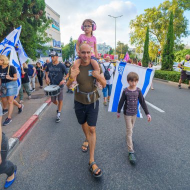 Hayfa, İsrail - 29 Haziran 2024: Hükümete karşı bir protesto yürüyüşü sahnesi, insanların katıldığı, çeşitli tabelalar ve bayraklarla yeni seçimler çağrısında bulundu. Hayfa, İsrail