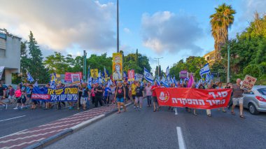 Hayfa, İsrail - 29 Haziran 2024: Hükümete karşı bir protesto yürüyüşü sahnesi, insanların katıldığı, çeşitli tabelalar ve bayraklarla yeni seçimler çağrısında bulundu. Hayfa, İsrail