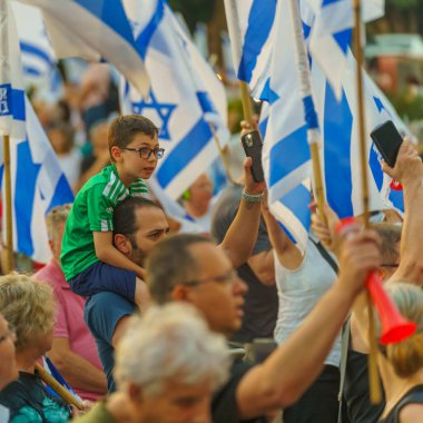 Hayfa, İsrail - 29 Haziran 2024: Çeşitli tabela ve bayraklı bir kalabalık hükümete karşı düzenlenen protesto mitingine katılarak yeni seçimler çağrısında bulundu. Hayfa, İsrail
