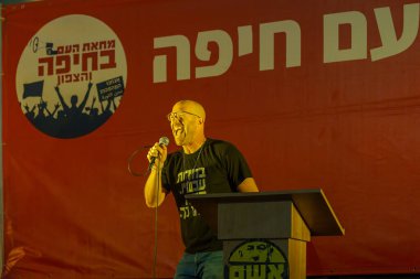 Hayfa, İsrail - 29 Haziran 2024: Asaf Fradkin, hükümete karşı düzenlenen bir protesto mitinginde kalabalığa şarkı söyledi, Hayfa, İsrail