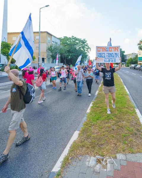 stock image Haifa, Israel - June 29, 2024: Scene of a protest march, against the government, calling for new elections, with people taking part, various signs and flags. Haifa, Israel