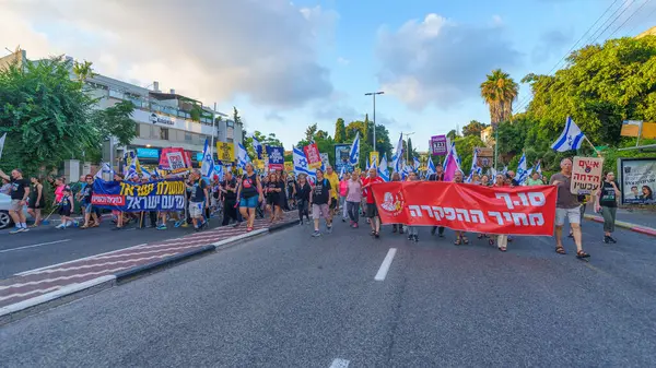 Stock image Haifa, Israel - June 29, 2024: Scene of a protest march, against the government, calling for new elections, with people taking part, various signs and flags. Haifa, Israel