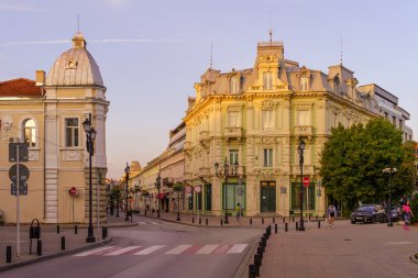 Rusçuk, Bulgaristan - 17 Eylül 2023: Bulgaristan 'ın kuzeydoğusundaki Rusçuk kentinde eski binalar, yerliler ve ziyaretçilerle Aleksandrovska caddesinin gün batımı manzarası