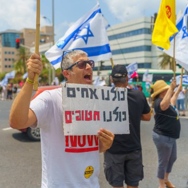 Hayfa, İsrail - 07 Temmuz 2024: İnsanlar büyük bir kavşağı tıkayan bayraklar, çeşitli işaretlerle protesto ediyorlar. Hükümete ve rehine ailelerine, Hayfa 'ya ve İsrail' e karşı yapılan müdahalenin bir parçası.