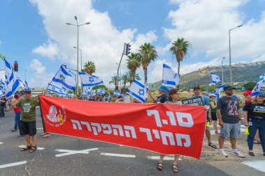 Hayfa, İsrail - 07 Temmuz 2024: İnsanlar büyük bir kavşağı tıkayan bayraklar, çeşitli işaretlerle protesto ediyorlar. Hükümete ve rehine ailelerine, Hayfa 'ya ve İsrail' e karşı yapılan müdahalenin bir parçası.