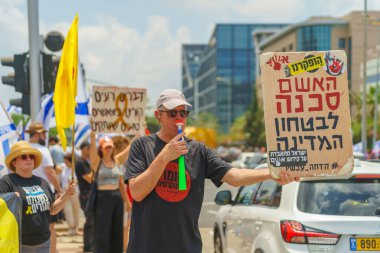 Hayfa, İsrail - 07 Temmuz 2024: İnsanlar büyük bir kavşağı tıkayan bayraklar, çeşitli işaretlerle protesto ediyorlar. Hükümete ve rehine ailelerine, Hayfa 'ya ve İsrail' e karşı yapılan müdahalenin bir parçası.