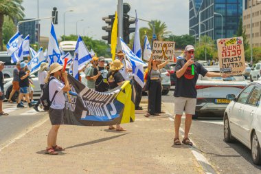 Hayfa, İsrail - 07 Temmuz 2024: İnsanlar büyük bir kavşağı tıkayan bayraklar, çeşitli işaretlerle protesto ediyorlar. Hükümete ve rehine ailelerine, Hayfa 'ya ve İsrail' e karşı yapılan müdahalenin bir parçası.