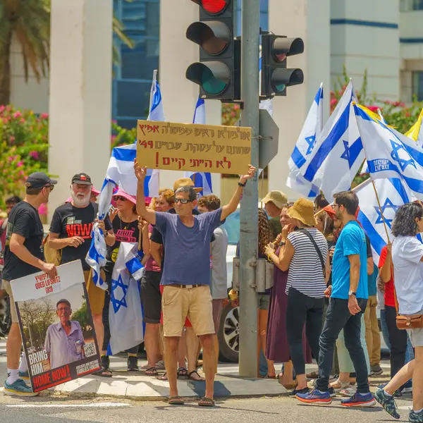 stock image Haifa, Israel - July 07, 2024: People protest with flags, various signs, blocking a major junction. Part of day of disruption against the government and support of hostages families, Haifa, Israel