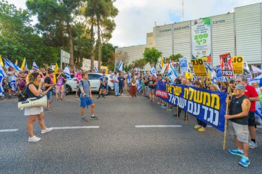 Hayfa, İsrail - Temmuz 06, 2024: Hükümete karşı bir protesto yürüyüşü sahnesi, insanların katıldığı, çeşitli tabelalar ve bayraklarla yeni seçimler çağrısında bulundu. Hayfa, İsrail