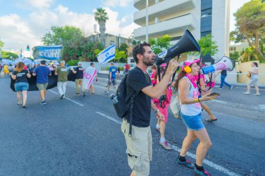 Hayfa, İsrail - Temmuz 06, 2024: Hükümete karşı bir protesto yürüyüşü sahnesi, insanların katıldığı, çeşitli tabelalar ve bayraklarla yeni seçimler çağrısında bulundu. Hayfa, İsrail
