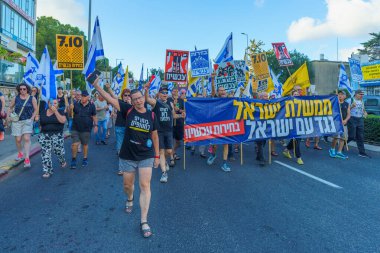 Hayfa, İsrail - Temmuz 06, 2024: Hükümete karşı bir protesto yürüyüşü sahnesi, insanların katıldığı, çeşitli tabelalar ve bayraklarla yeni seçimler çağrısında bulundu. Hayfa, İsrail