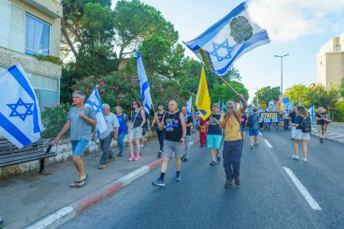 Hayfa, İsrail - Temmuz 06, 2024: Hükümete karşı bir protesto yürüyüşü sahnesi, insanların katıldığı, çeşitli tabelalar ve bayraklarla yeni seçimler çağrısında bulundu. Hayfa, İsrail