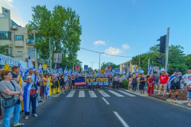 Hayfa, İsrail - Temmuz 06, 2024: Hükümete karşı bir protesto yürüyüşü sahnesi, insanların katıldığı, çeşitli tabelalar ve bayraklarla yeni seçimler çağrısında bulundu. Hayfa, İsrail