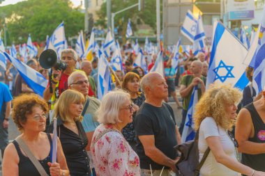 Hayfa, İsrail - 06 Temmuz 2024: Çeşitli tabela ve bayraklı bir kalabalık hükümete karşı düzenlenen protesto mitingine katılarak yeni seçimler çağrısında bulundu. Hayfa, İsrail