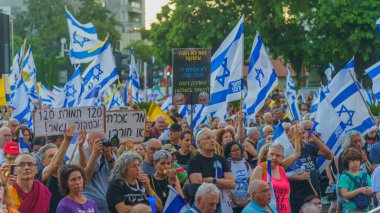 Hayfa, İsrail - 06 Temmuz 2024: Çeşitli tabela ve bayraklı bir kalabalık hükümete karşı düzenlenen protesto mitingine katılarak yeni seçimler çağrısında bulundu. Hayfa, İsrail
