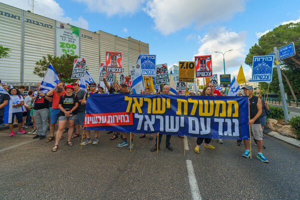 Haifa, Israel - July 06, 2024: Scene of a protest march, against the government, calling for new elections, with people taking part, various signs and flags. Haifa, Israel